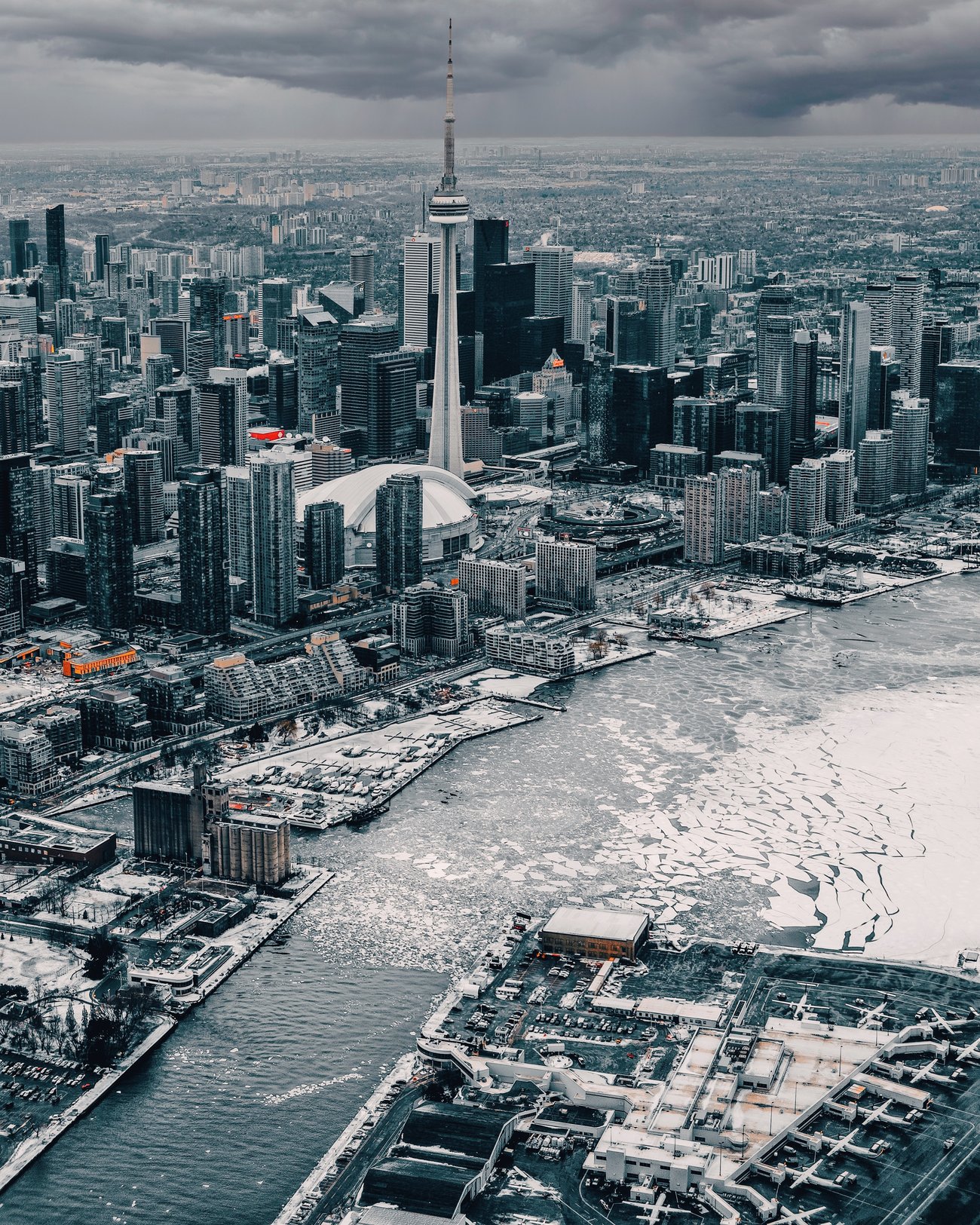 CN Tower and Toronto shoreline in Canada seen from the icy harbor on an overcast winter day