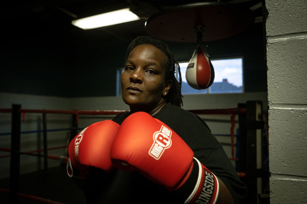 Portrait of Black female boxer wearing red boxing gloves and looking at camera