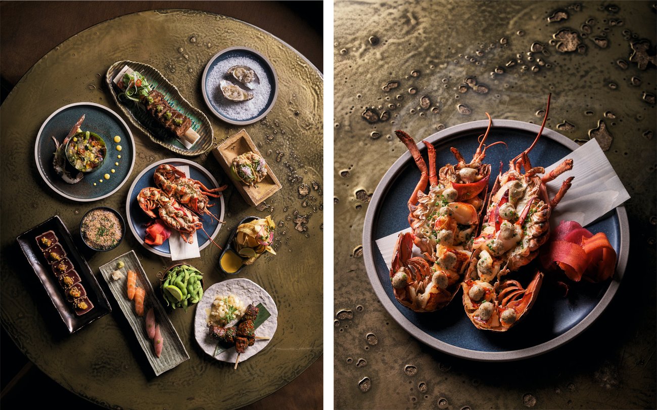 Top view of table with sushi, edamame, and lobster dishes / Top view of lobster dish halved open on blue plate