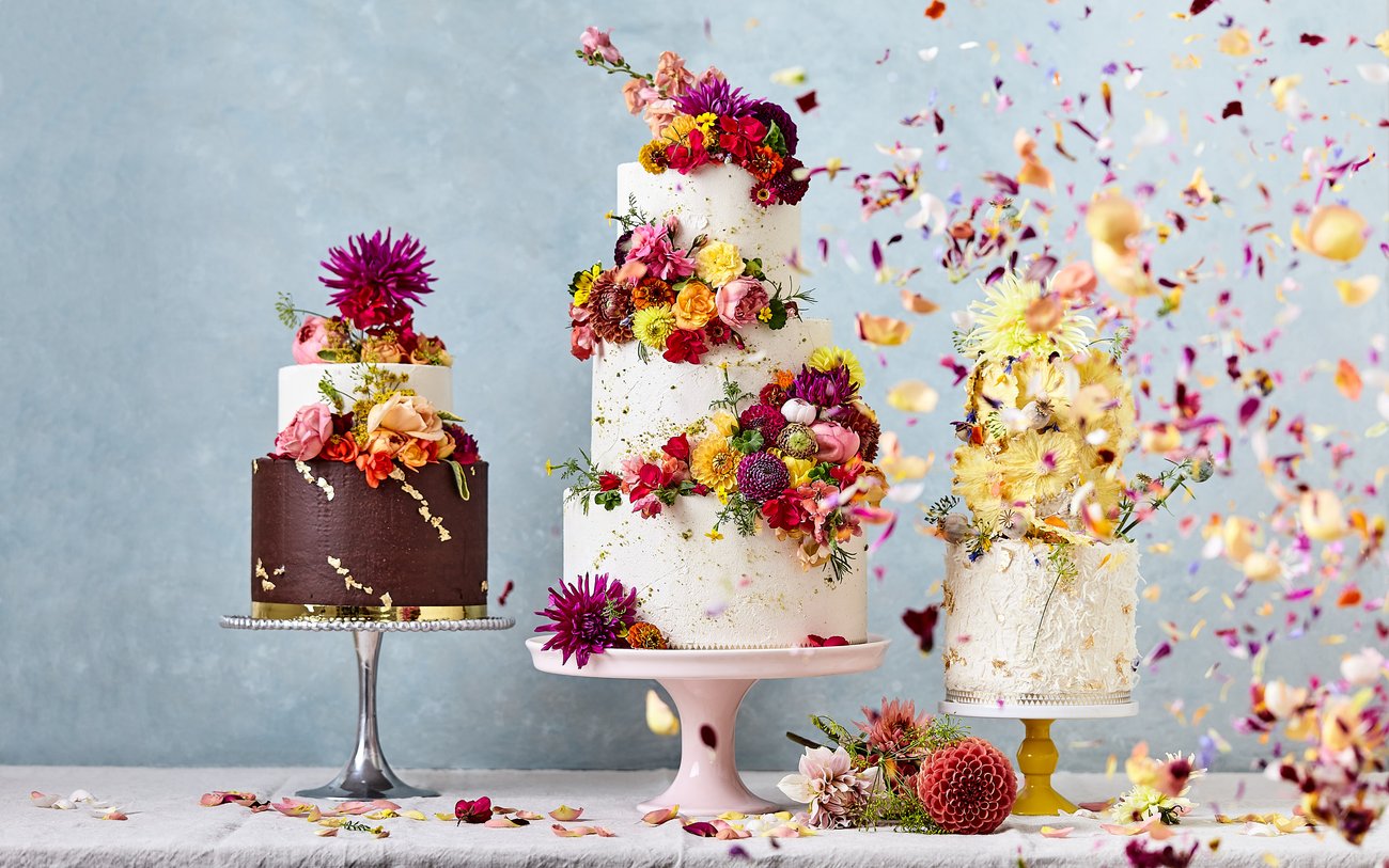 Three, three tiered cakes with floral decorations and petal confetti