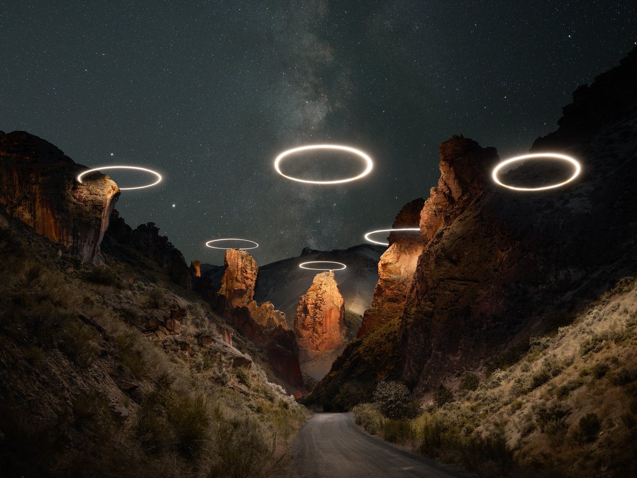 Circles of light in a triangle formation over top a deserted valley road at night