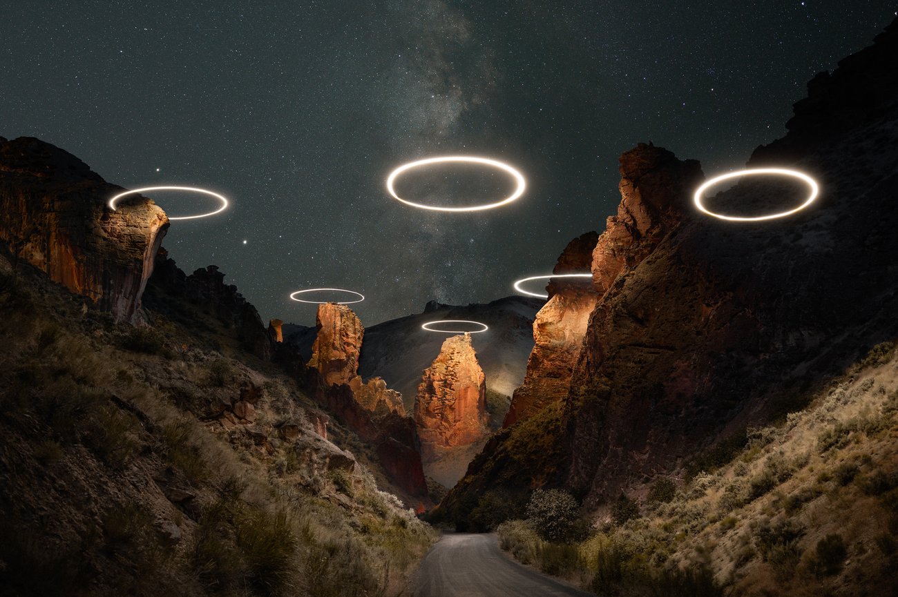 Circles of light in a triangle formation over top a deserted valley road at night