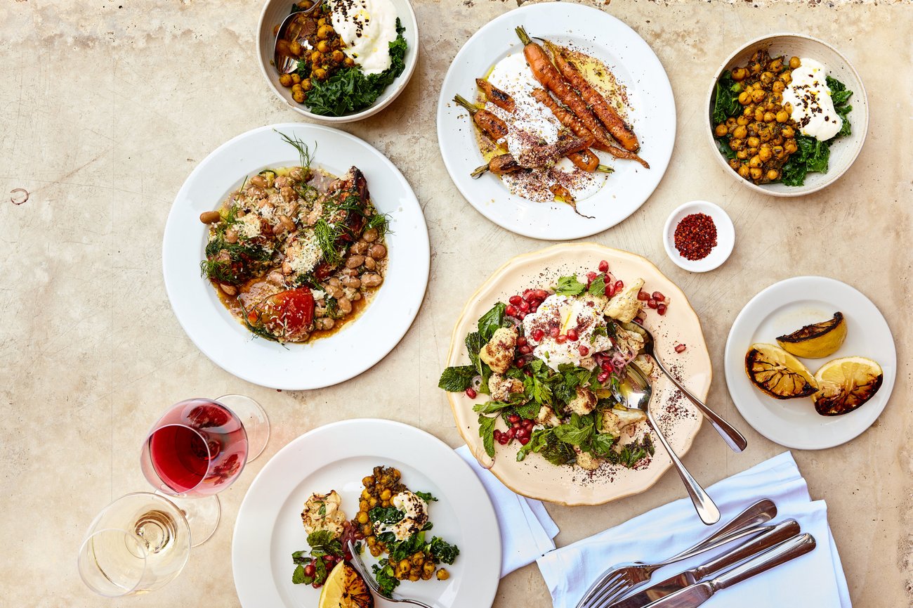 Bird’s eye view of various types of plated food on a simple off-white table